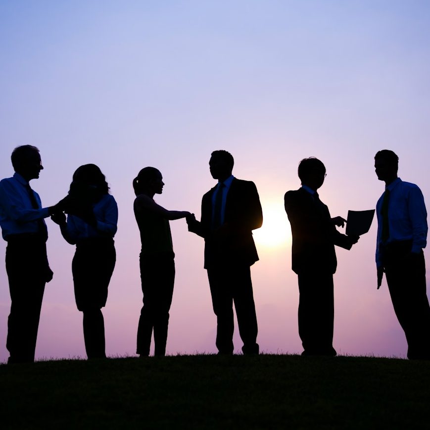Silhouettes de personnes en discussion lors d'un coucher de soleil.